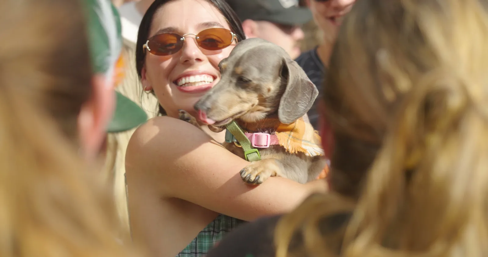 A festival-goer cuddling her dachshund before the race